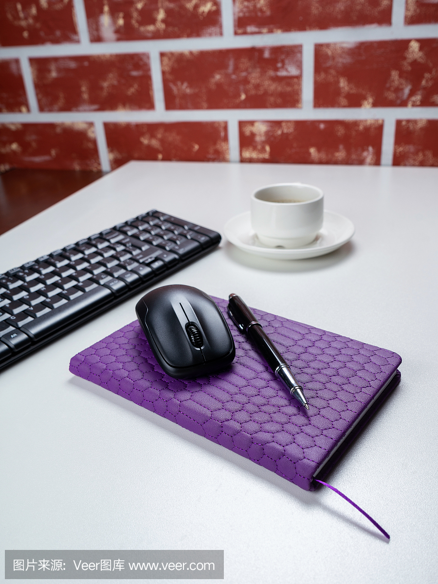 办公室桌子桌子上。工作空间与笔记本,键盘,办公用品和咖啡杯在白色的背景。